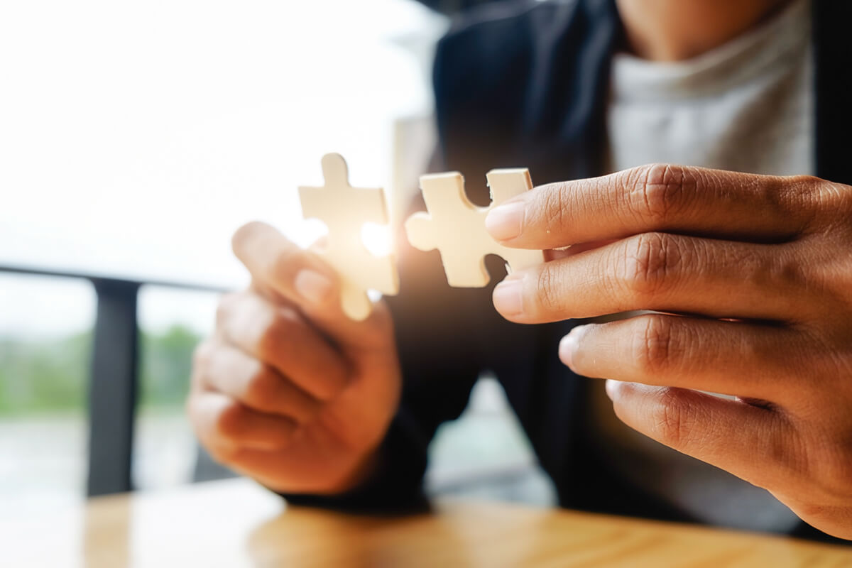 Zwei Puzzleteile in der Hand