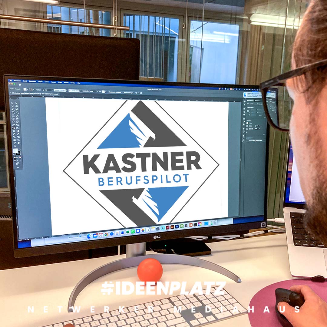 Man sieht über die Schultern von einem Mann mit Brill und schwarzen Haaren auf einen Bildschirm. Auf dem Bildschirm sieht man das Logo von Berufspilot Kevin Kastner